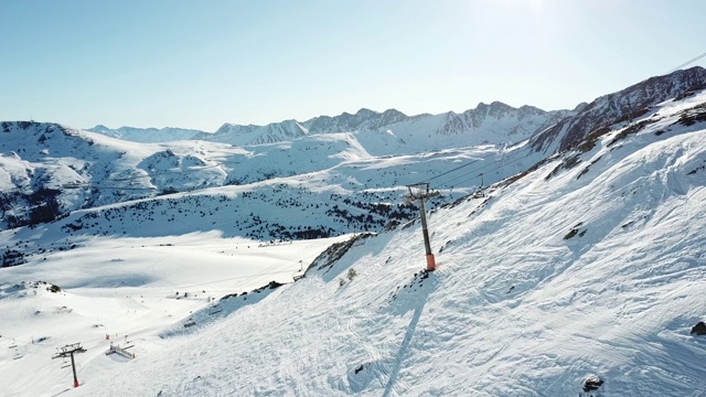 安道尔滑雪胜地格兰德瓦利拉缆车拍摄的画面。摄像机平稳地升起，展现出比利牛斯山脉的全景。清晨柔和的光。冬季的山景视频素材