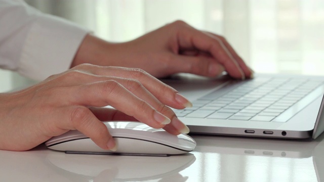 特写女性的手，商务女性使用鼠标与笔记本电脑工作视频下载