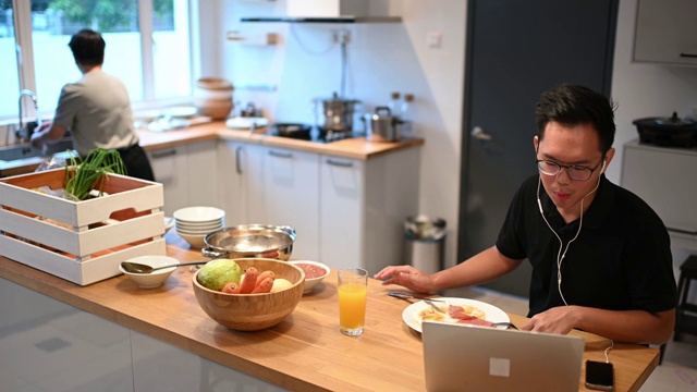 亚洲华人母亲和儿子在厨房餐厅吃早餐早上视频下载
