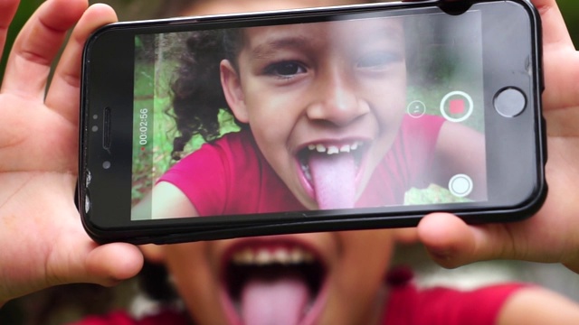 女孩在公园里拍摄自己的舌头视频下载