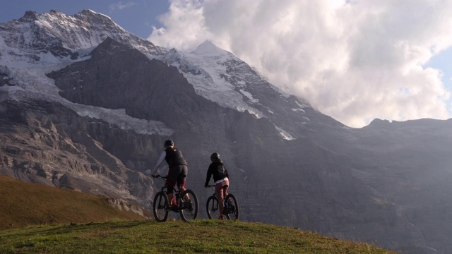 日出时，女山地自行车手穿越山地草地视频下载
