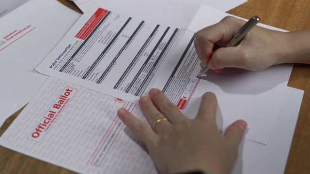在家里签署美国缺席选票表格的妇女视频下载