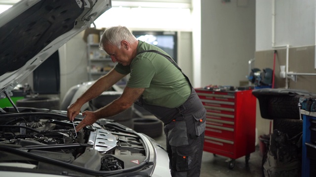 机械师在汽车修理厂检查汽车罩视频下载