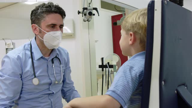 儿科医生在诊所检查一个男孩的喉咙视频素材