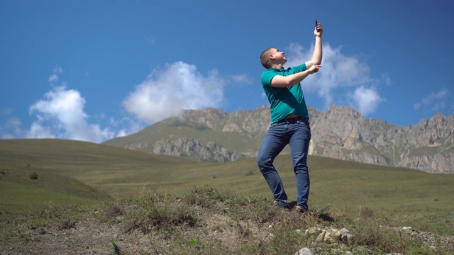 一个年轻人正在高加索山脉寻找手机网络。这个人正在讲电话，但是线路被打断了。视频下载