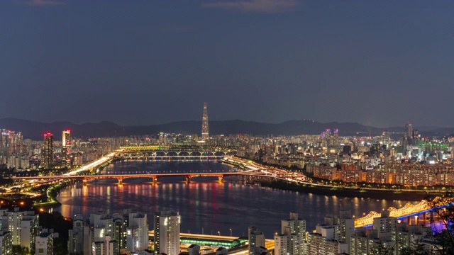 从白天到夜晚的城市景观，有乐天世界大厦和韩河/城东谷和江南谷的城须大学城大桥，韩国首尔视频素材