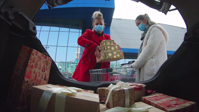 2019冠状病毒病大流行期间，家庭购买圣诞礼物。他们戴着防护口罩，以防止冠状病毒感染。视频下载