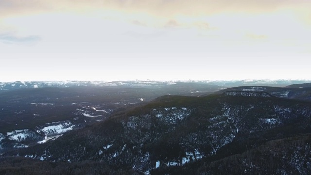 冬季日出时树木繁茂的山脉的航拍镜头(加拿大阿尔伯塔省)视频素材