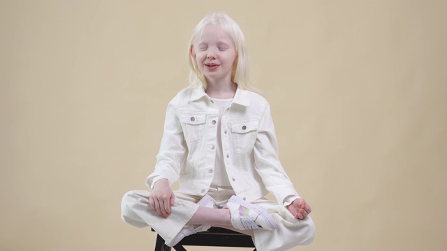 可爱的白化病儿童模型在莲花姿势冥想视频下载