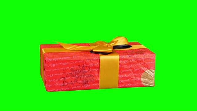 包装精美的礼物，目前孤立在绿色背景。特写,旋转。圣诞节或新年。节日包装、礼盒视频素材