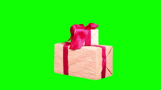 包装精美的礼物，礼物孤立在绿色背景。特写,旋转。圣诞节或新年。节日包装、礼盒视频素材