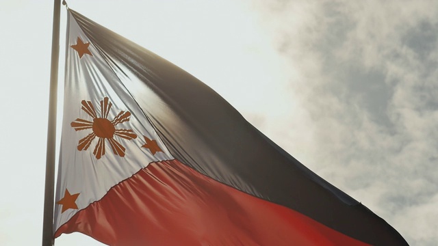 悬挂着菲律宾双色国旗，中央金色的太阳代表各省，星星代表岛屿视频下载