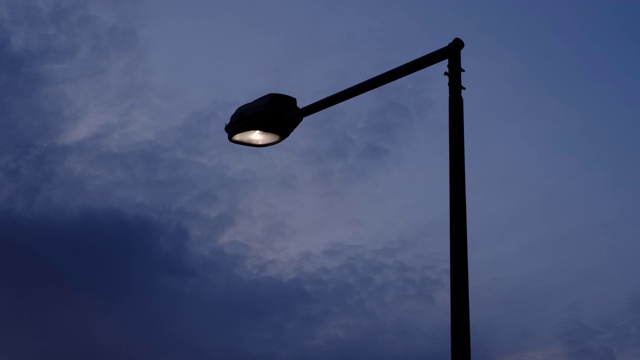 到了傍晚，照亮城市街道的路灯自动打开。视频素材