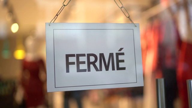 店主转向关门的标志(fermé)在店面门口视频素材