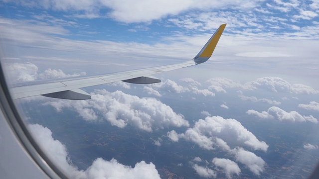 飞机飞行。从飞机窗口可以看到白云和蓝天。视频素材