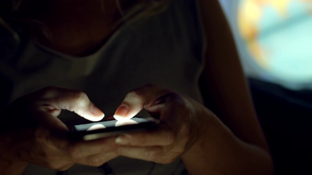 一名女子晚上在家用智能手机上网视频素材