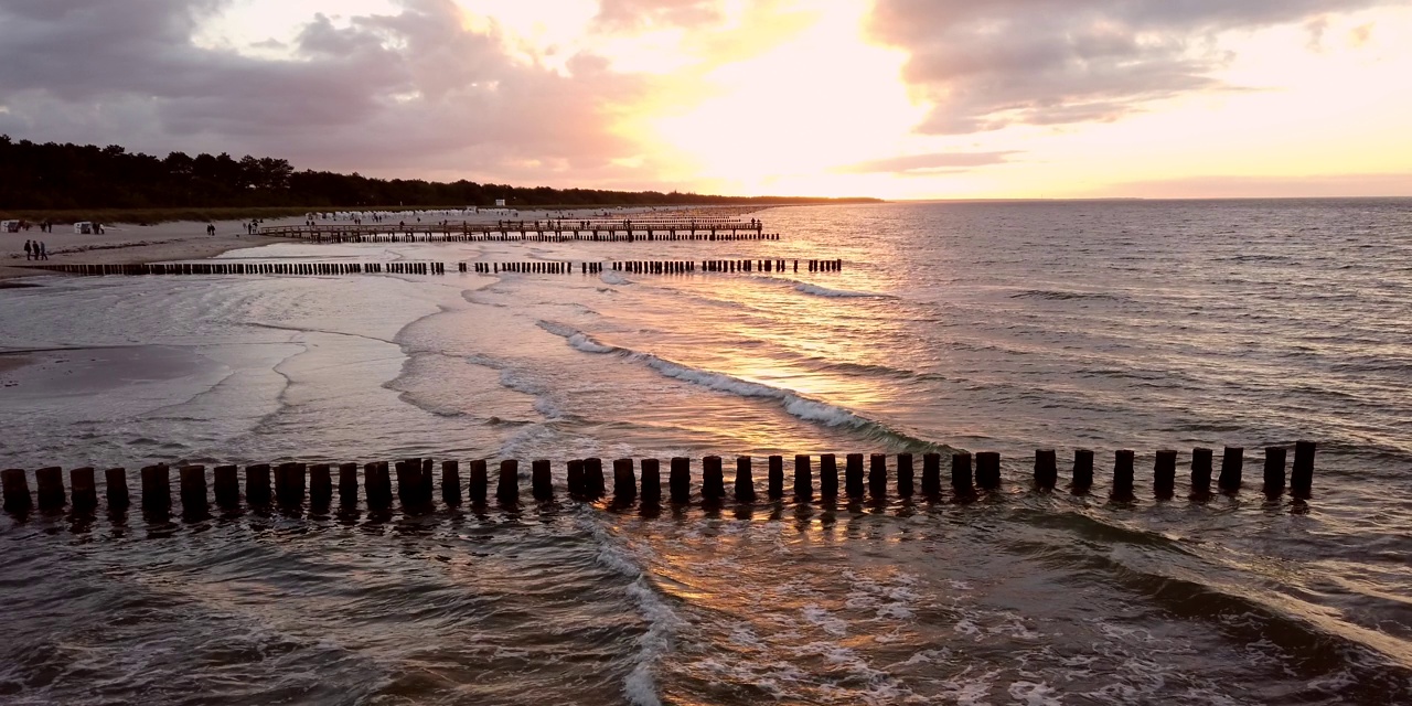 浪漫的日落与海浪在海滩上，groynes海岸保护，波罗的海视频素材