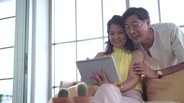 快乐的亚洲老年夫妇用数码平板电脑与海外家庭视频通话视频素材