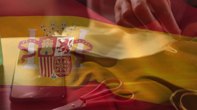 西班牙国旗飘扬在正在缝制面罩的妇女中间视频下载