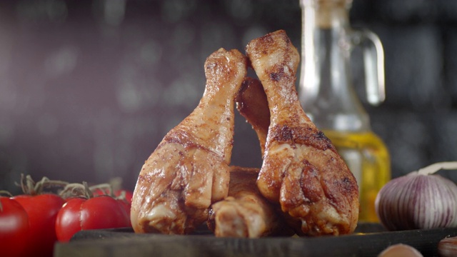 美味的炸鸡腿在切菜板上旋转。视频下载