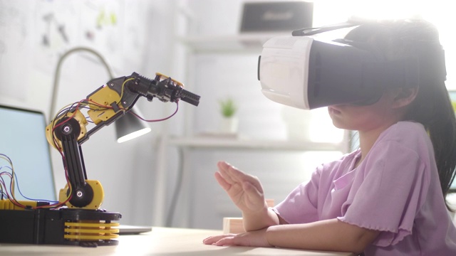 女孩用VR眼镜用手控制机器人手臂视频素材