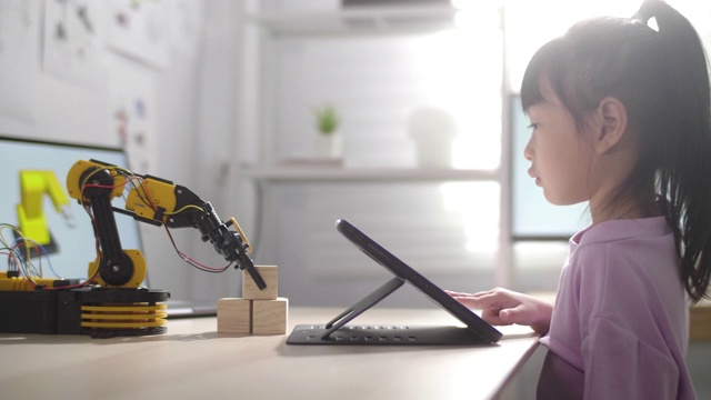 女孩用数字平板电脑控制机器人手臂用她的手视频下载