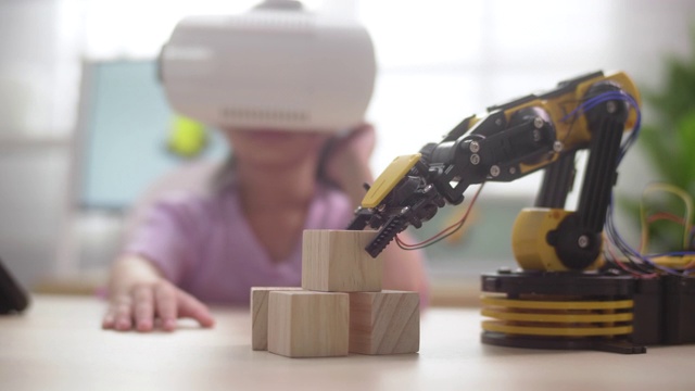 女孩控制与机械机器人手臂使用VR眼镜视频购买