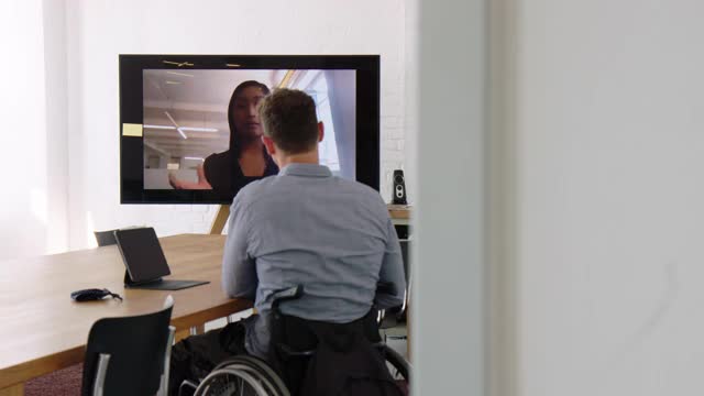 一位坐在轮椅上的商人正在和一位同事进行在线会议视频下载