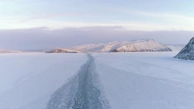 一架无人机降落在冰湖上的一艘船留下的痕迹上。视频素材