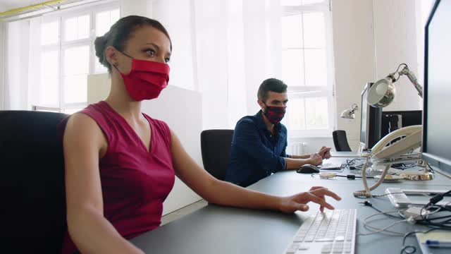 两个戴着口罩的商人在办公室工作视频素材