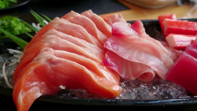 新鲜鲑鱼，金枪鱼和油甘鱼冰碟。日本料理生鱼片套装。平移。视频素材