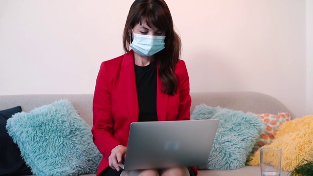 戴面具的女经理开始使用笔记本电脑。处理数字数据的计算机。视频素材