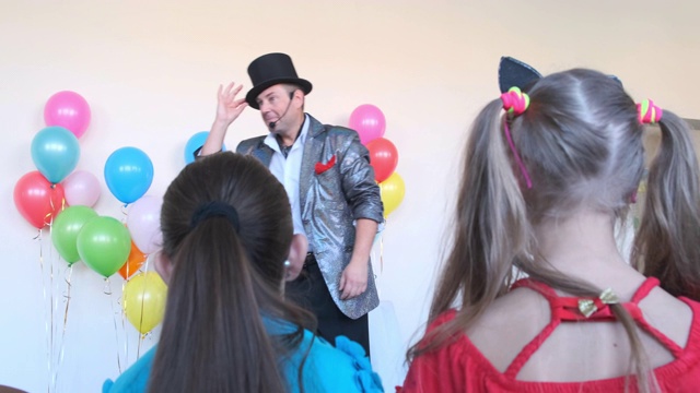 戴大礼帽的快乐男子在生日聚会上向孩子们问好视频下载