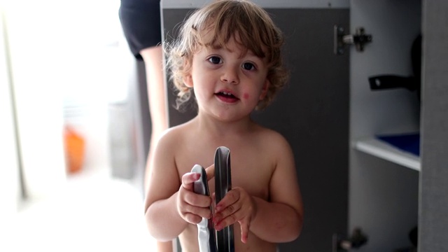 婴儿和婴儿玩厨房用具。蹒跚学步的孩子玩金属器具视频素材