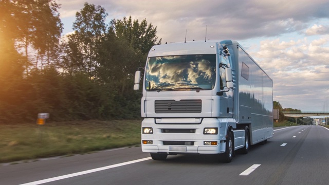 在高速公路上行驶的带有拖车的货运卡车。白色卡车在清晨运送货物视频下载