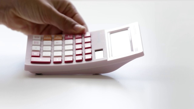 女人把粉红色的计算器放在桌子上-特写视频下载