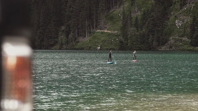 夏天一对夫妇在河上玩桨板视频素材