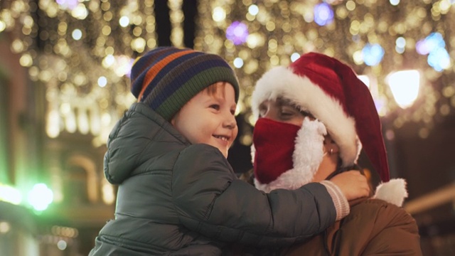 2019冠状病毒病大流行期间，一家人在城市街道上欣赏圣诞彩灯视频素材