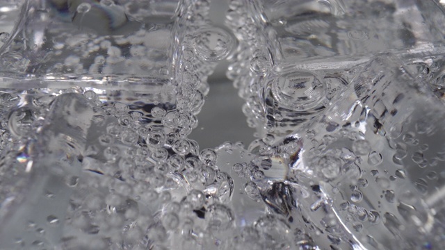 冰块在一杯碳酸纯矿泉水中旋转视频素材