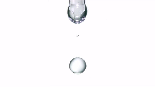 特写和慢动作的透明液体油滴从实验室移液管在白色背景视频素材