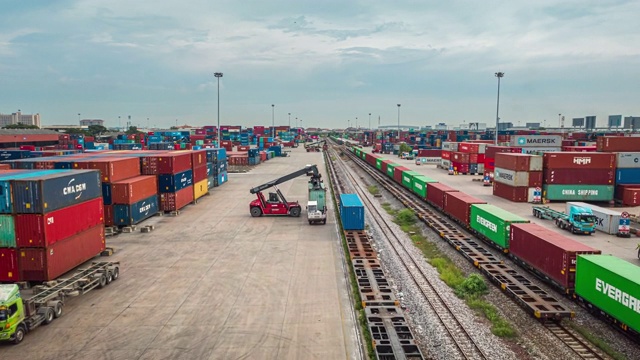 4K时间延时或超延时:码头商埠集装箱仓库繁忙的交通，移动起重机将集装箱装载到货运列车，商业物流进出口运输或货运运输。视频素材