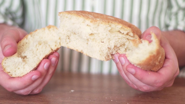 手擘饼。有害的碳水化合物。面包师撕新鲜的面包特写视频素材