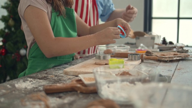 “爸爸和女儿在厨房的柜台上做圣诞饼干。视频素材
