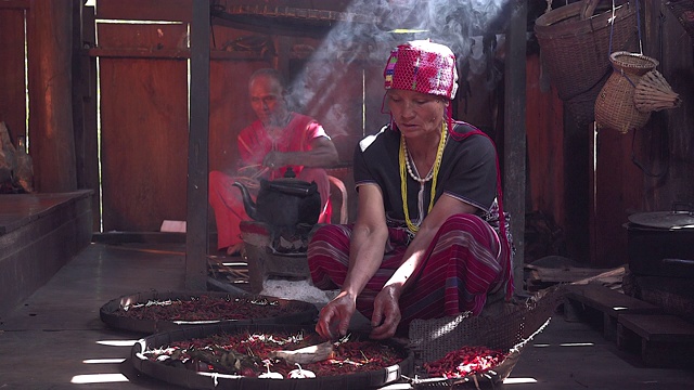 卡伦老妇人坐在分开的干辣椒准备食物摄于卡伦的房子后面是一个没有现代技术的木制厨房。视频下载