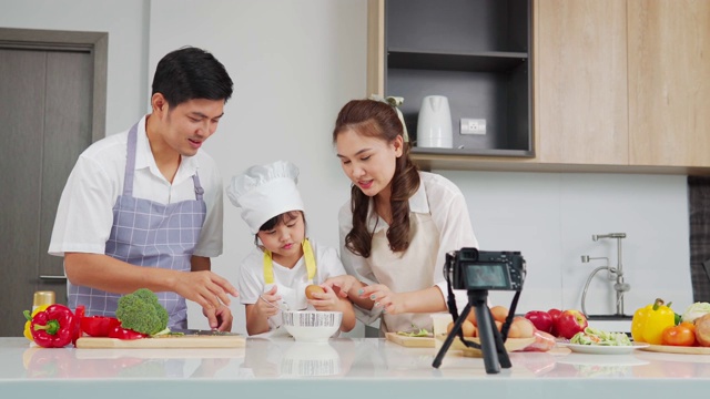 快乐的家庭用数码相机做沙拉。厨房里的在线直播数码相机。视频下载