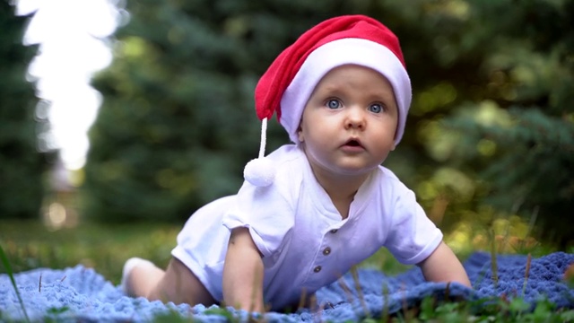 戴着圣诞老人帽子的蓝眼睛小婴儿。视频下载