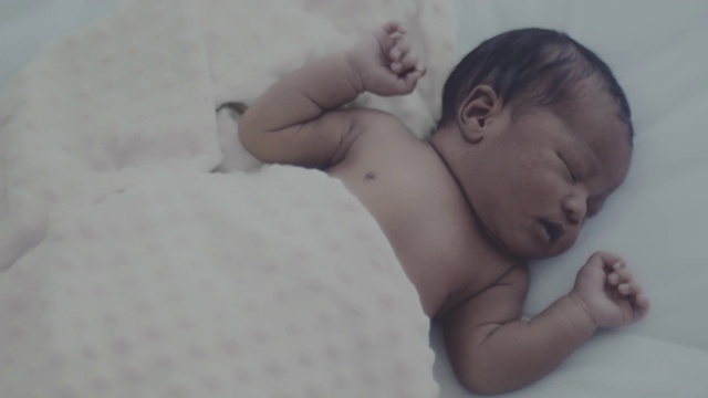 新生儿躺在白色的小床上视频下载