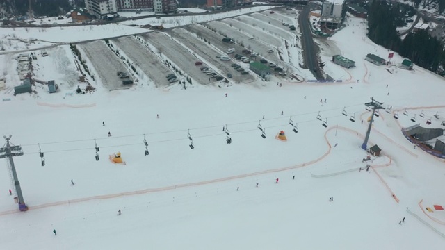 鸟瞰图:滑雪场、斜坡、缆车。索道把滑雪者吊到山上。冬季活动。视频下载