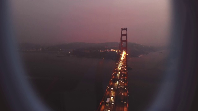 飞机窗口与金门大桥在旧金山高峰夜。视频下载