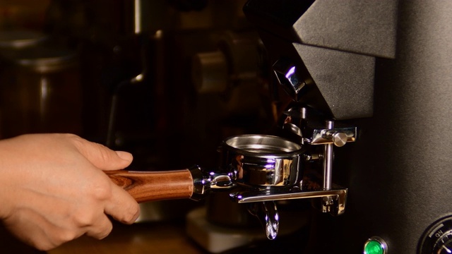 咖啡机正在准备新鲜的咖啡。滤纸架的特写，上面有咖啡机压碎的粉末。餐厅或酒吧的专业酿造。视频素材